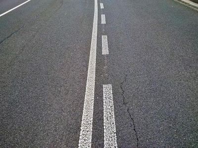 What does a solid white line indicate on the road?