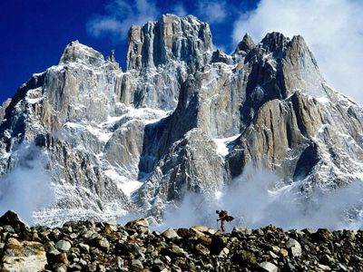 Which landform is characterized by a steep, vertical or overhanging face?