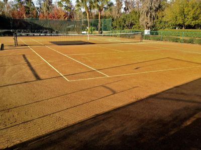 Which Grand Slam tournament is known for its red clay courts?