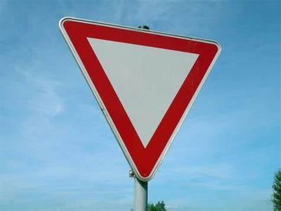 What must you do when approaching a yield sign on a roundabout?