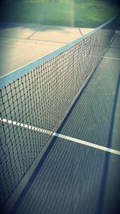 Which game is played on a court divided into front and back areas with a net in the middle?