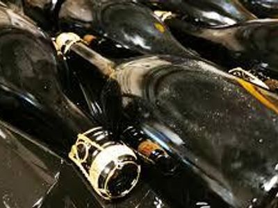 What process involves rotating sparkling wine bottles to move sediment toward the neck?