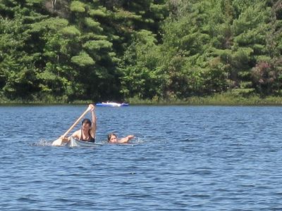 Which technique is used to safely flip a swamped canoe back upright?