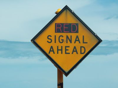 What does a red 'X' over a lane signal indicate on a highway?