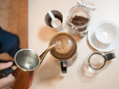 Which brewing method involves pouring hot water over ground coffee in a long, slow process?