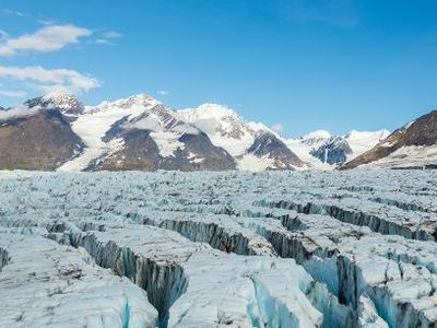 Which landform is characterized by a steep, vertical drop and can be formed by glaciers?