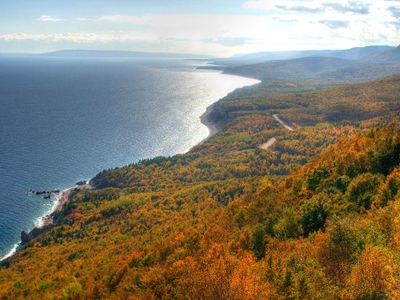 Which country is home to the famous Cabot Trail, a scenic biking route along the coast?