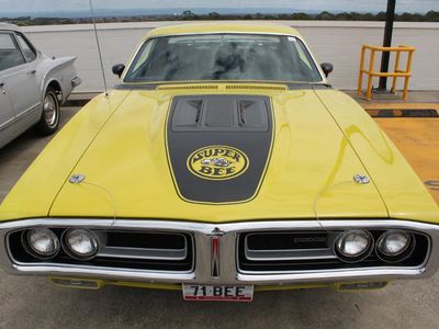 Which muscle car features a Super Bee emblem?