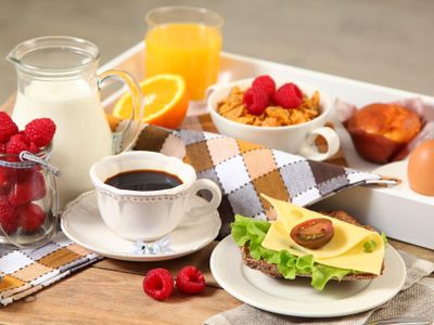 sausage, soft-boiled eggs, cereal, fruit, jam, and marmalade