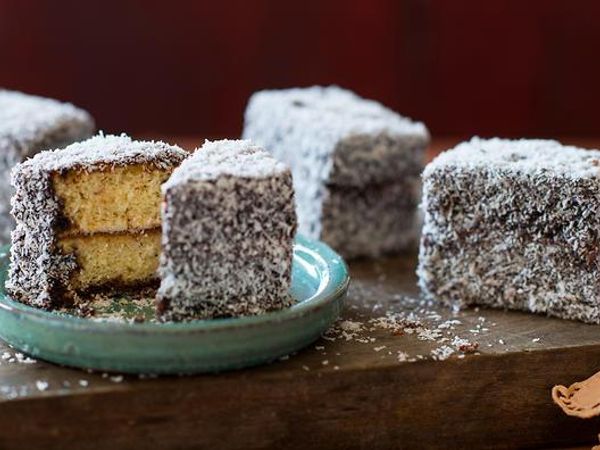 Lamington A lamington is a small square of sponge cake, filled with jam, dipped in chocolate and rolled in shredded coconut.