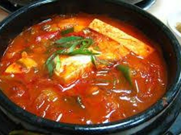 "Jjigae is a Korean dish similar to a Western stew. There are many varieties; it is typically made with meat, seafood or vegetables in a broth seasoned with gochujang, doenjang, ganjang or saeujeot. Jjigae is usually served in a communal dish and boiling hot."