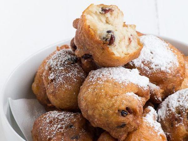 Oliebol Donut/dumpling.  by using an ice cream scoop or two spoons to scoop a certain amount of dough and dropping the dough into a deep fryer filled with hot oil, a sphere-shaped oliebol emerges.