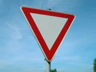 What must you do when approaching a yield sign on a roundabout?