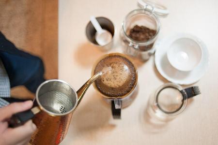 Which brewing method involves pouring hot water over ground coffee in a long, slow process?